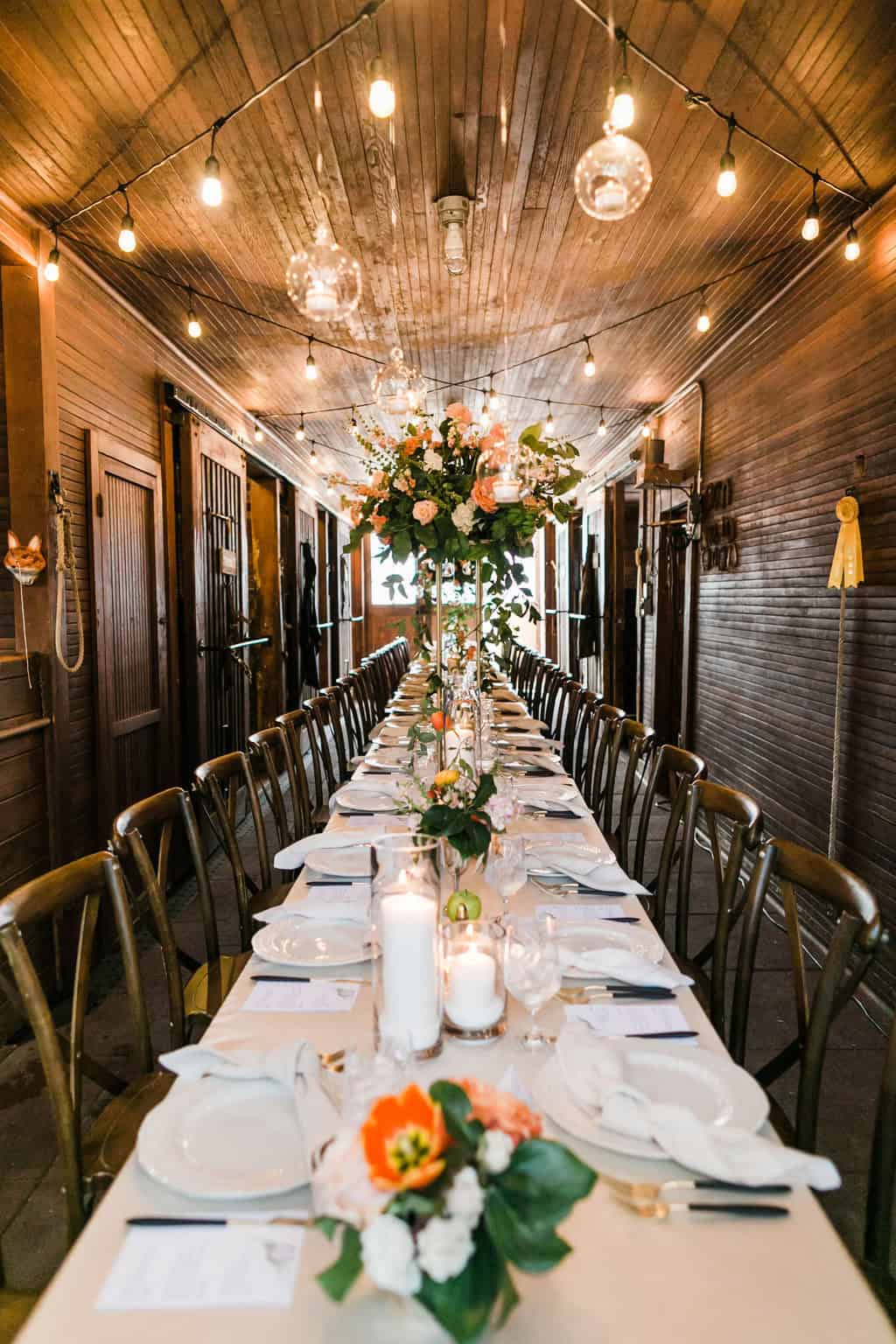 Elegant wedding reception table with floral centerpiece and string lights.