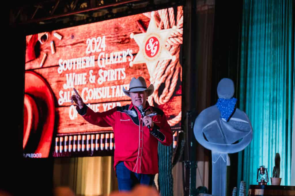 Speaker at Southern Glazers Awards Gala 2024 with stage backdrop.