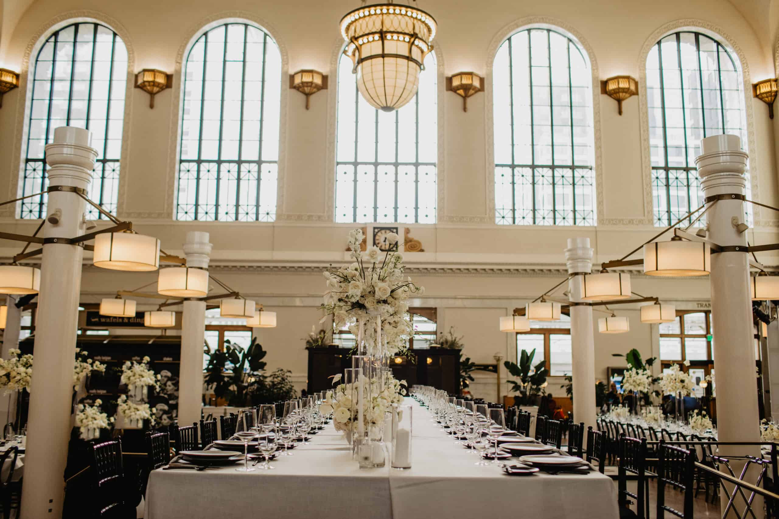 Elegant banquet setup with floral centerpieces in a grand hall.