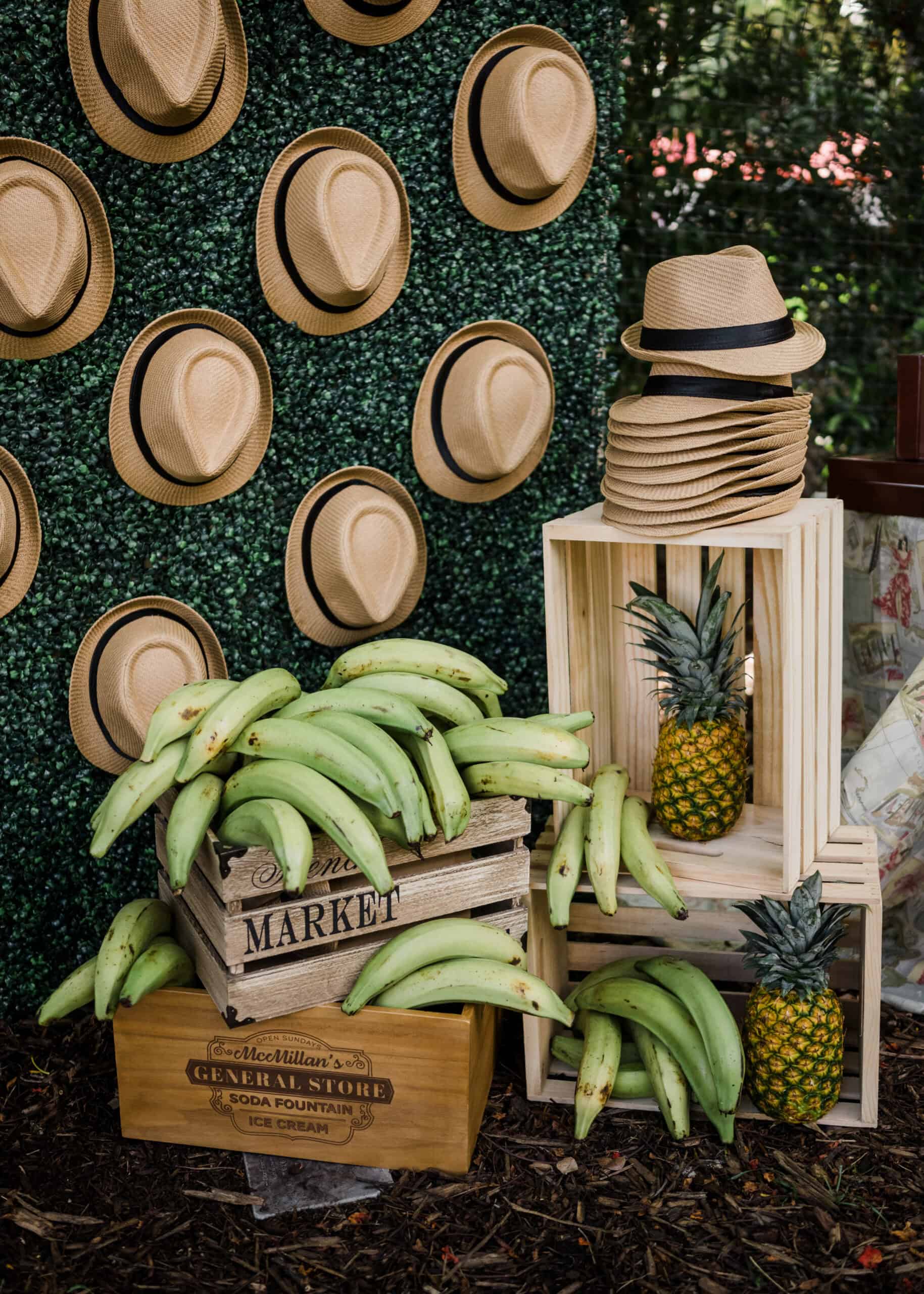Display of straw hats and fresh bananas at an outdoor market stall.