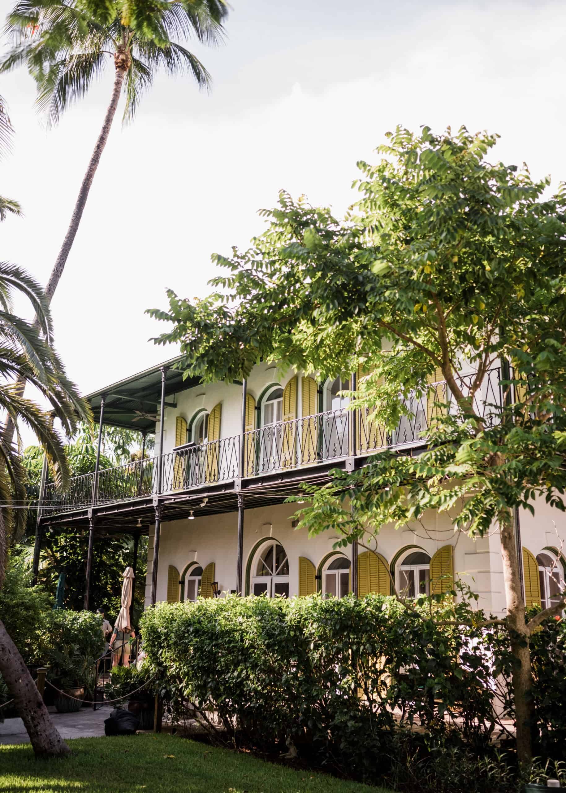 Elegant tropical venue with lush greenery and a two-story building for events.