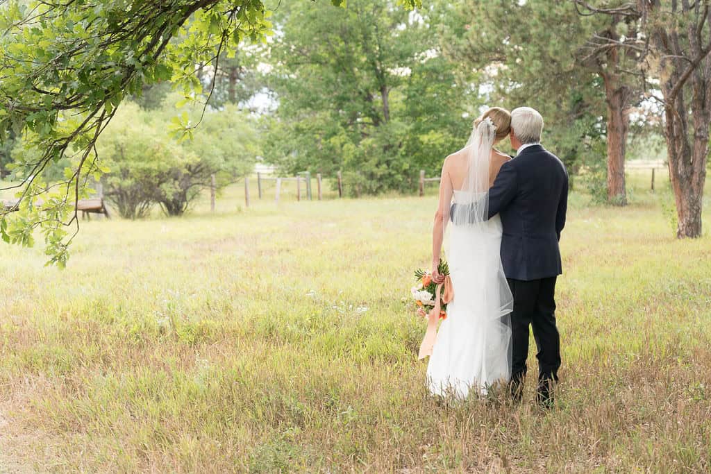 Bride and groom standing in a lush green outdoor setting.