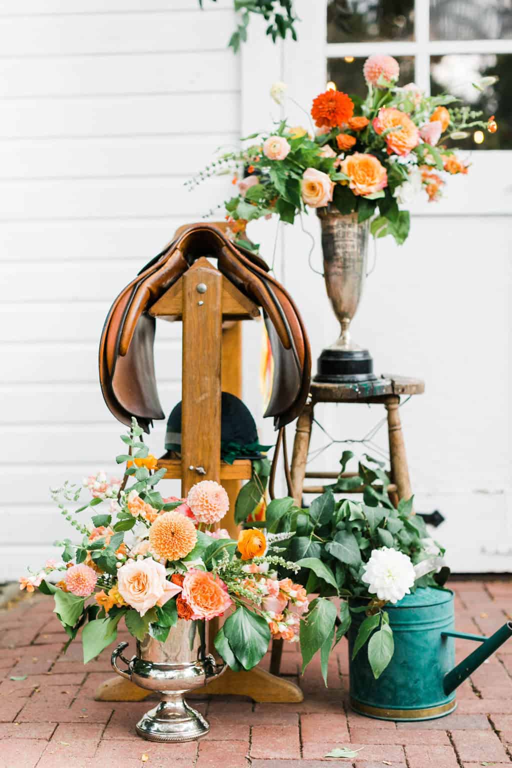 Elegant floral arrangement with saddle and watering can for luxury wedding decor.