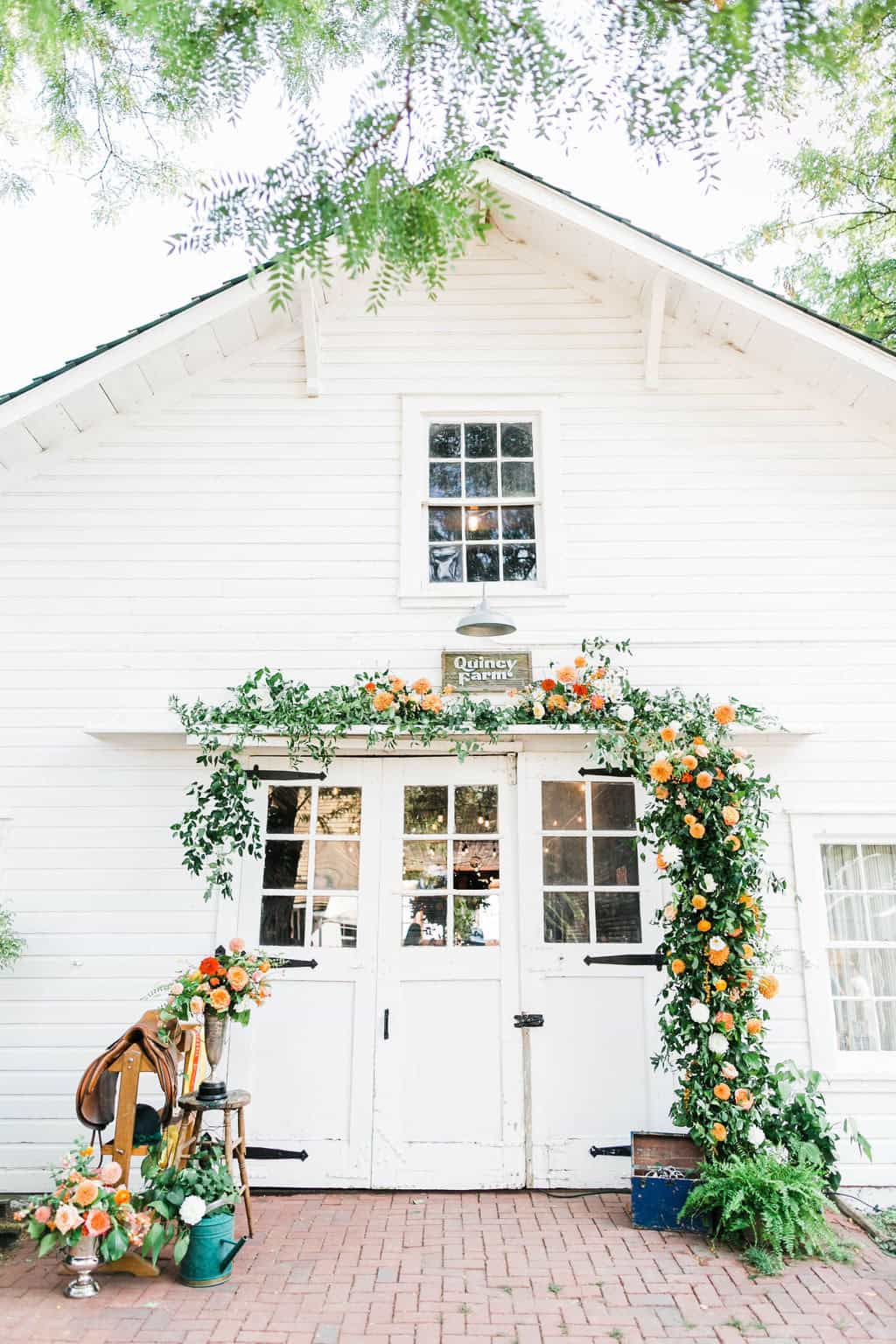 Elegant white wedding venue with floral arch and greenery for luxury weddings.